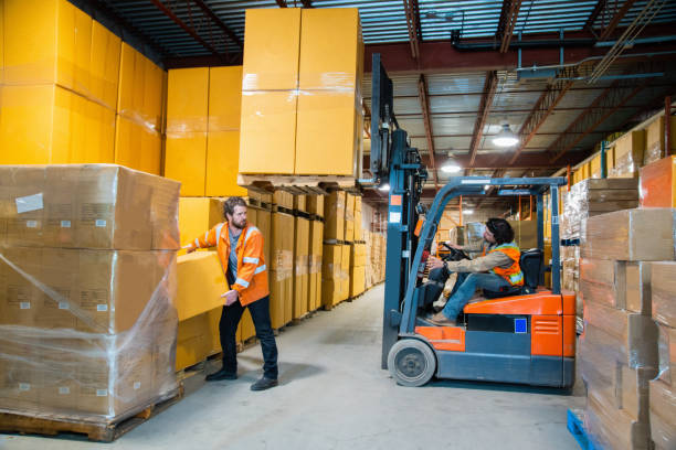 Warehouse operator driving a Toyota forklift dangerously close to a co-worker. 